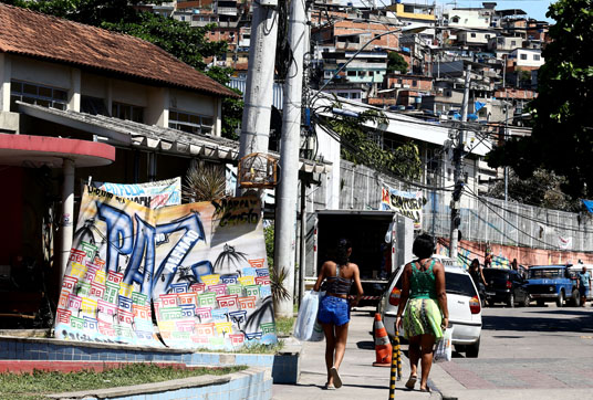 Uma faixa pede paz em uma das entradas do Complexo de Favelas do Alemão, na zona norte do Rio. (Foto: Wilton Junior/Estadão)