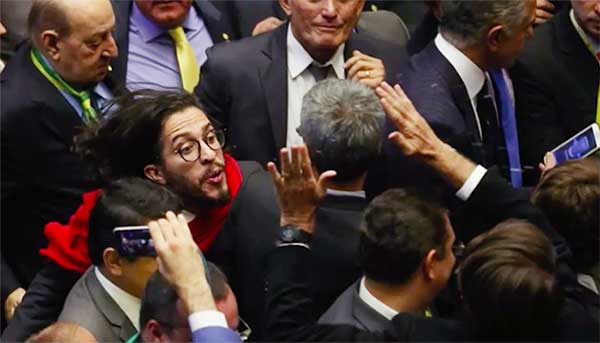 O deputado Jean Wyllys (de vermelho) cospe no deputado Jair Bolsonaro (com braços levantados) em plena Câmara dos Deputados - Foto: reprodução