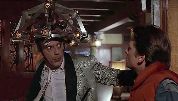 O incrível e maluco Dr. Emmett Brown (Christopher Lloyd, à esquerda) tenta usar uma invenção em Marty McFly (Michael J. Fox), no filme “De Volta para o Futuro” – Imagem: divulgação