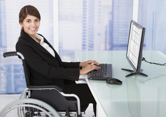 Businesswoman Using Computer While Sitting On Wheelchair