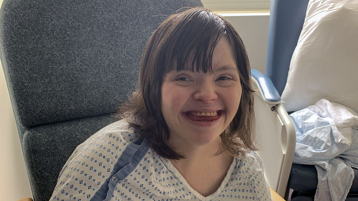 Foto de Amanda Ross, mulher de 36 anos que tem síndrome de Down, no dia em que recebeu alta do hospital. Ela está sorrindo e olhando para a câmera. Crédito: Reprodução.