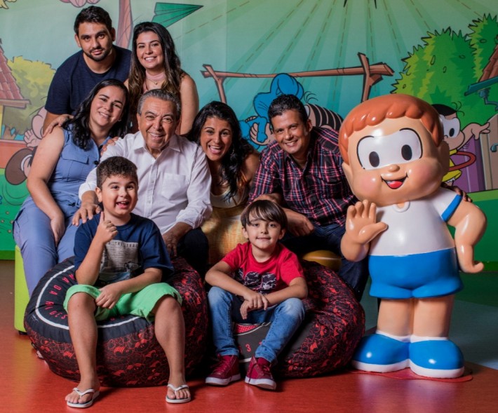 Foto do cartunista Maurício de Sousa com uma das famílias que participam do livro 'Amor Raro' e o personagem Edu, que tem a Distrofia Muscular de Duchenne e foi incluído na Turma da Mônica em 2019. Crédito: Divulgação.