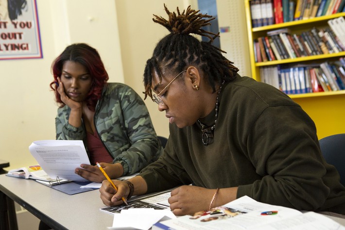 Foto de duas pessoas trans negras estudando em uma biblioteca. Crédito: Divulgação.
