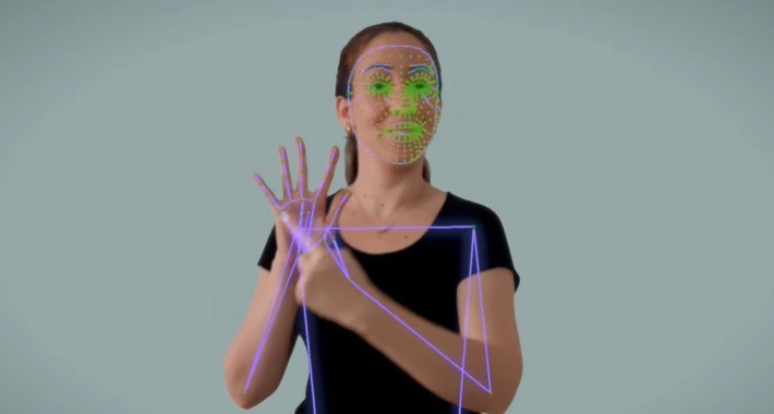 Foto de uma mulher fazendo sinais de Libras. Imagem tem riscos sobre o corpo da mulher, demostrando o sistema que reconhece movimentos.