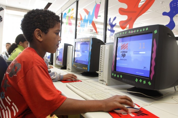Foto de um menino negro usando um computador.