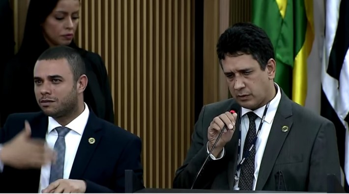 Foto do secretário naciona dos direitos das pessoas com deficiência durante discurso ao lado de um intérprete de Libras.