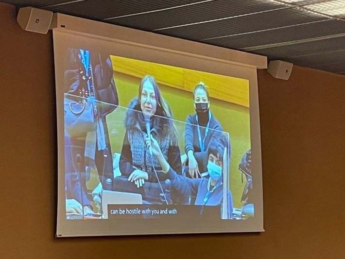 Foto de um monitor de vídeo que mostra a senadora Mara Gabrilli falando ao microfone em reunião da ONU em Genebra.