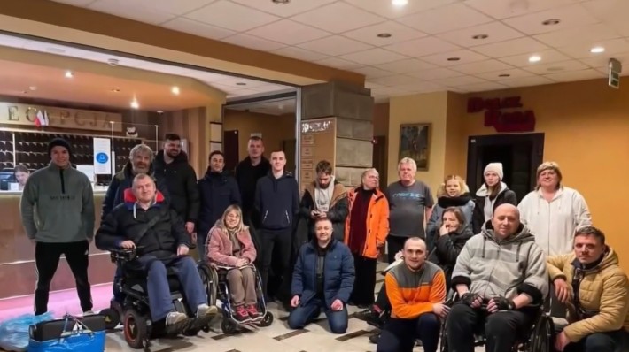 Foto de um grupo de pessoas com e sem deficiência no saguão de um hotel.
